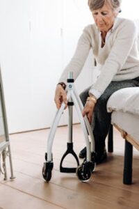 Elderly woman adjusting her rollator walker indoors, emphasizing mobility and independence.